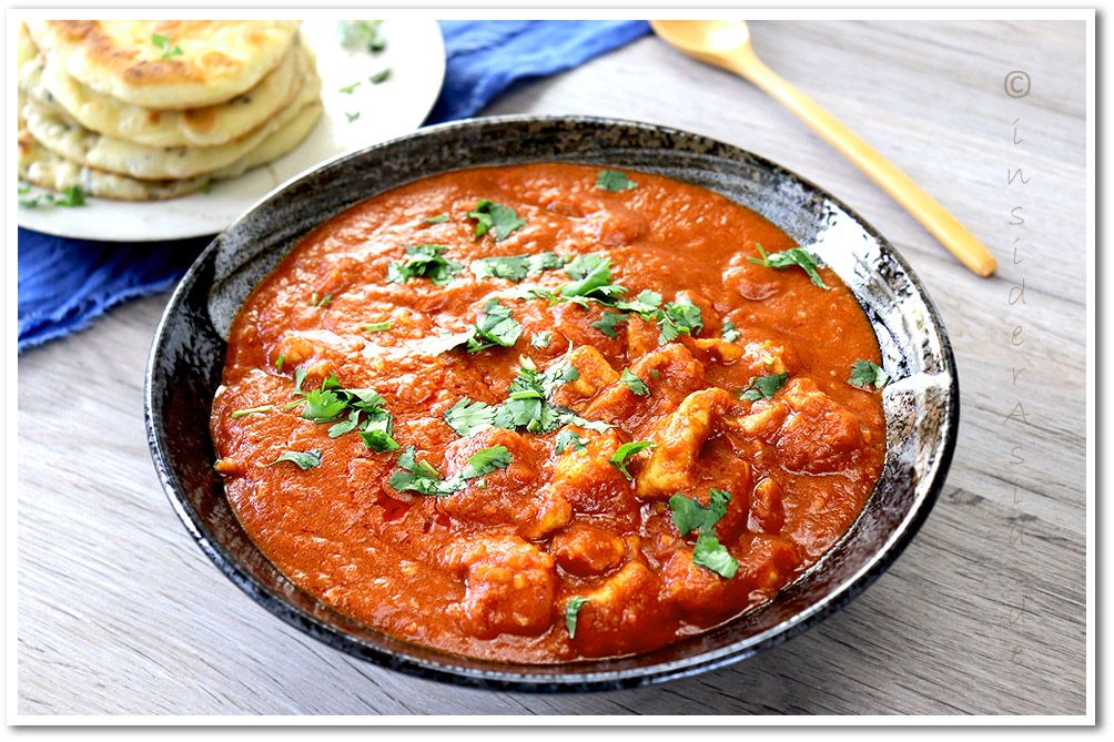 Indisches Curry Butter Chicken in einer großen Schale neben Naan Brot